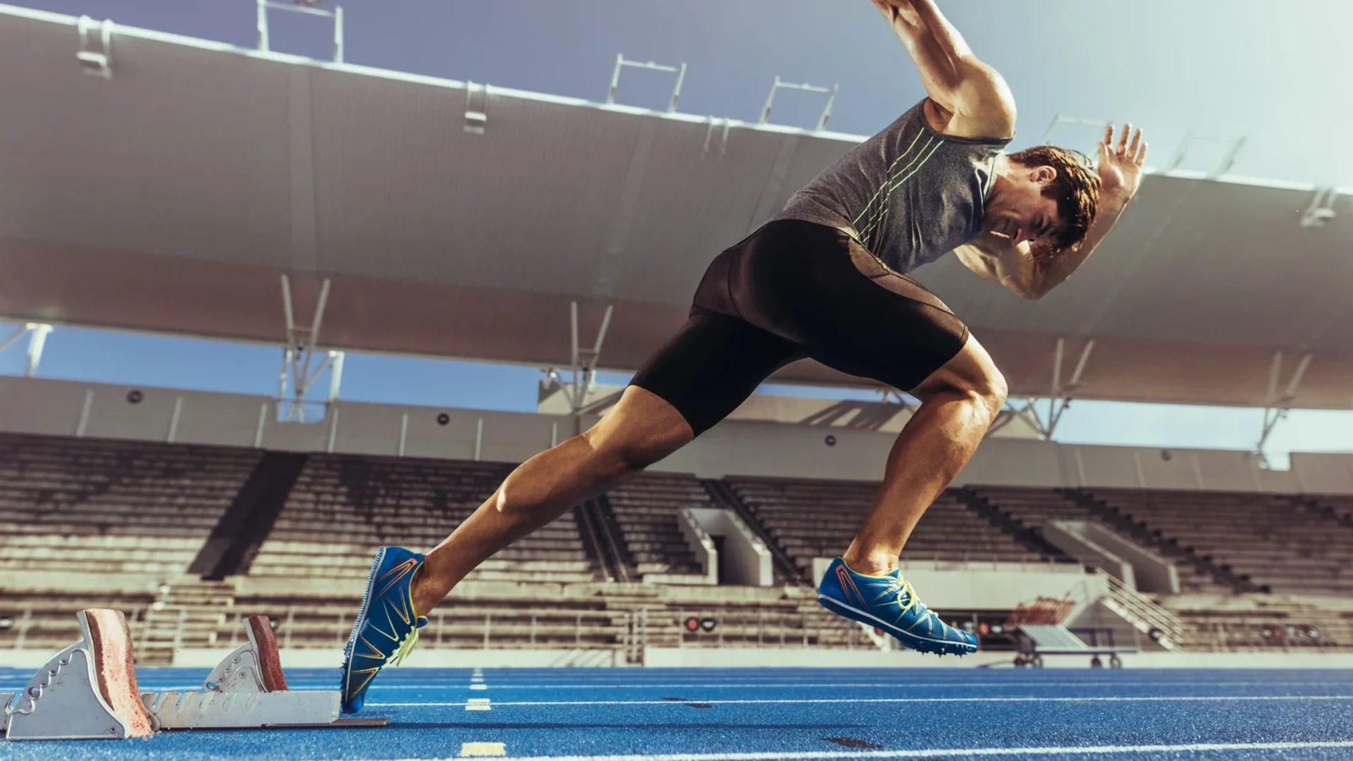 A sprinter driving out of the starting blocks